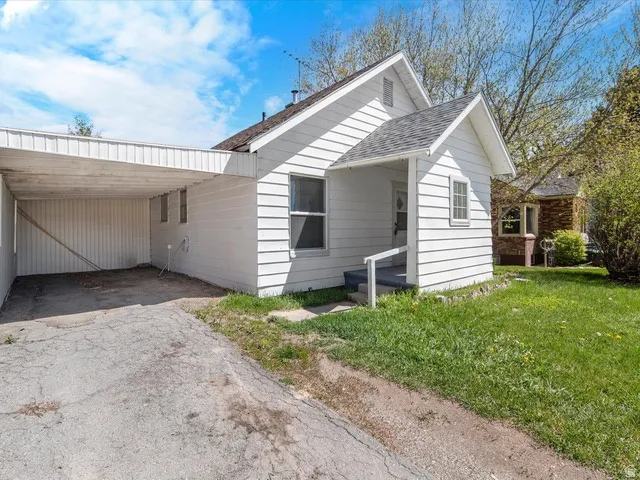 White siding exterior with a carport and concrete driveway