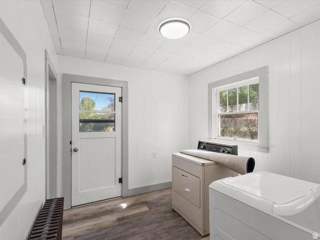 Utility room featuring wood-finish flooring and white plank walls