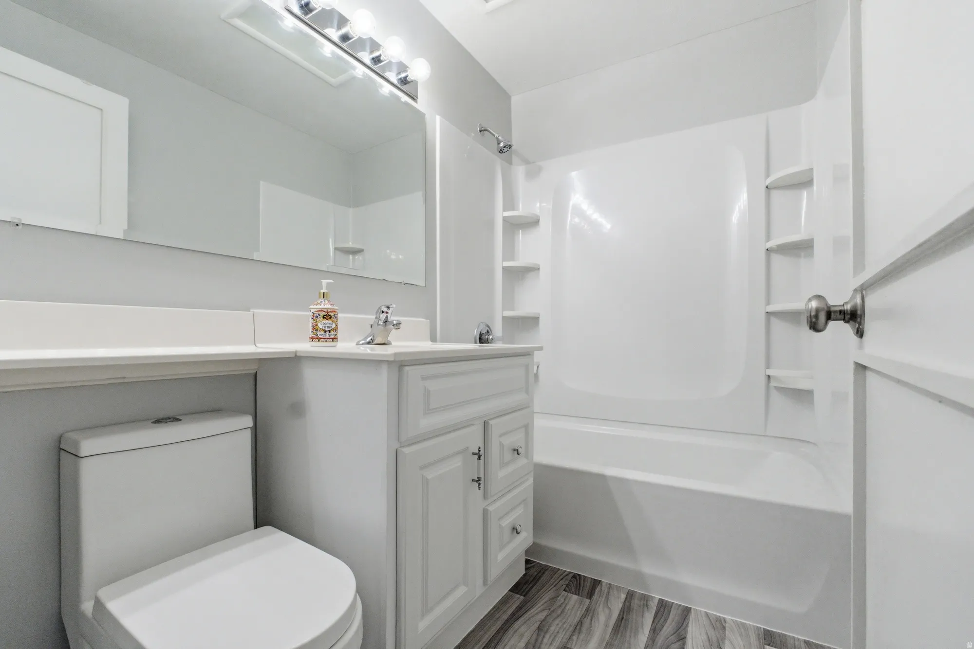 Bathroom featuring a white vanity with cabinet storage, a white countertop, and a large wall-mounted mirror