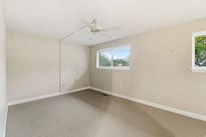 Carpeted room with a ceiling fan