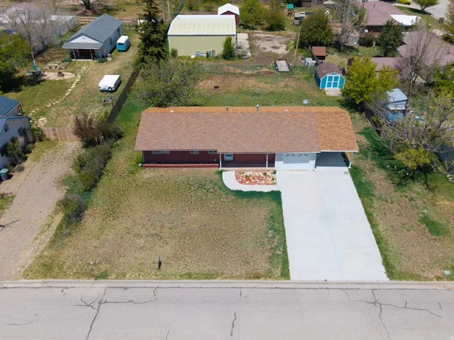 Ranch-style residence featuring a brick exterior and a brown shingle roof
