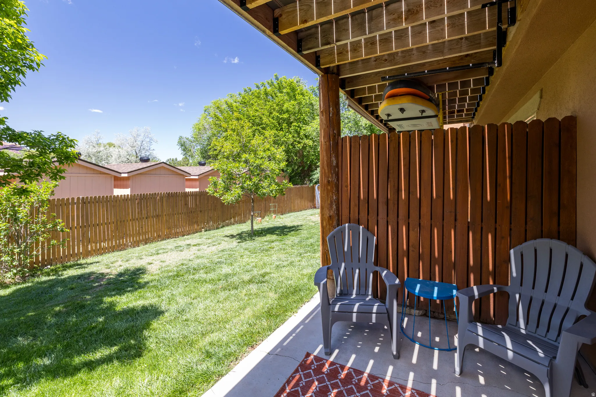 Private patio with concrete flooring, accented by a wood-slat privacy screen
