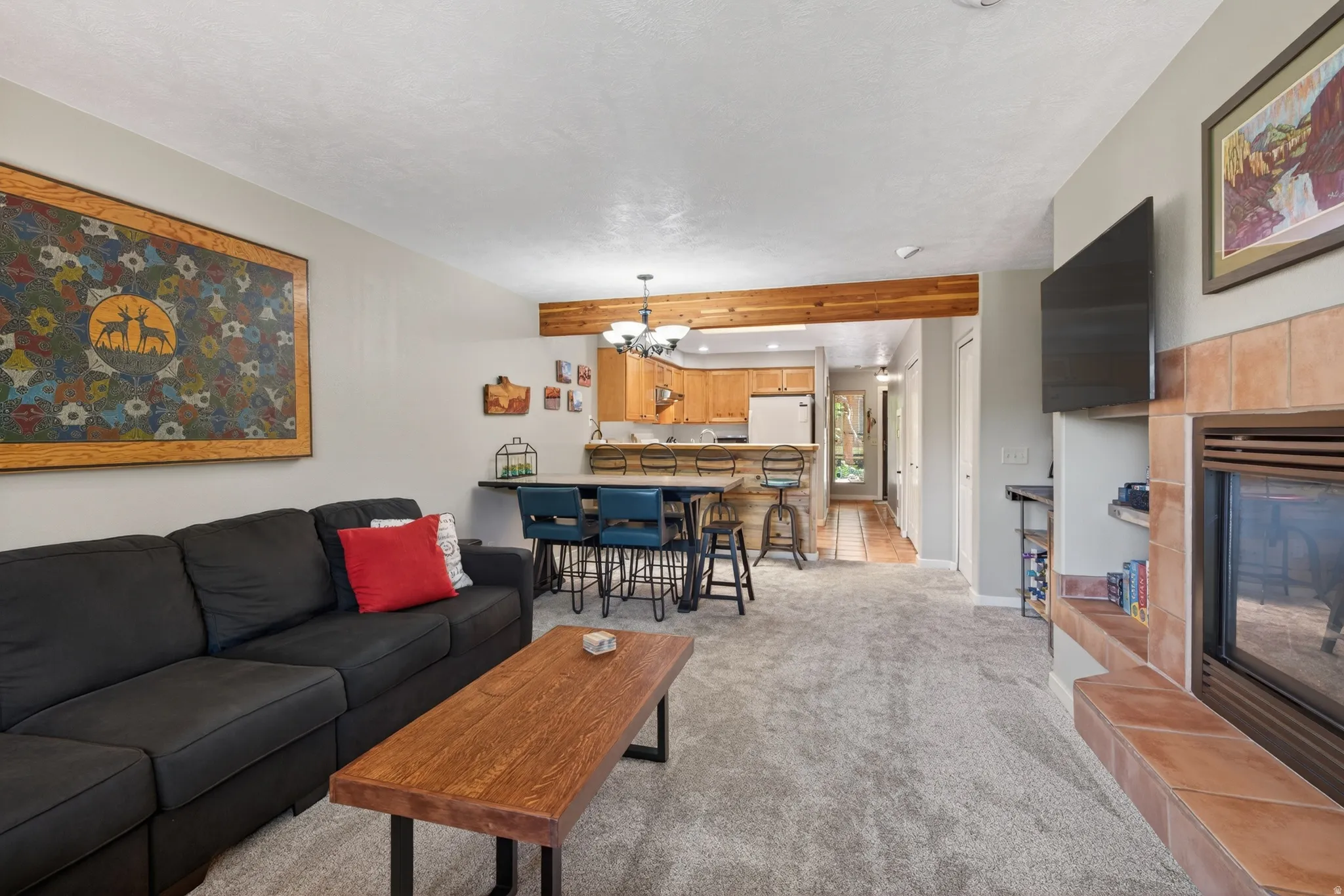 Open-concept living area featuring light gray walls and plush gray carpeting