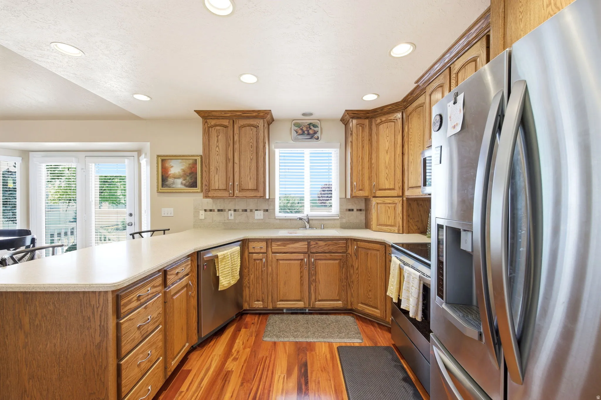 Kitchen featuring wood-finish flooring, light-toned countertops, and wood cabinetry