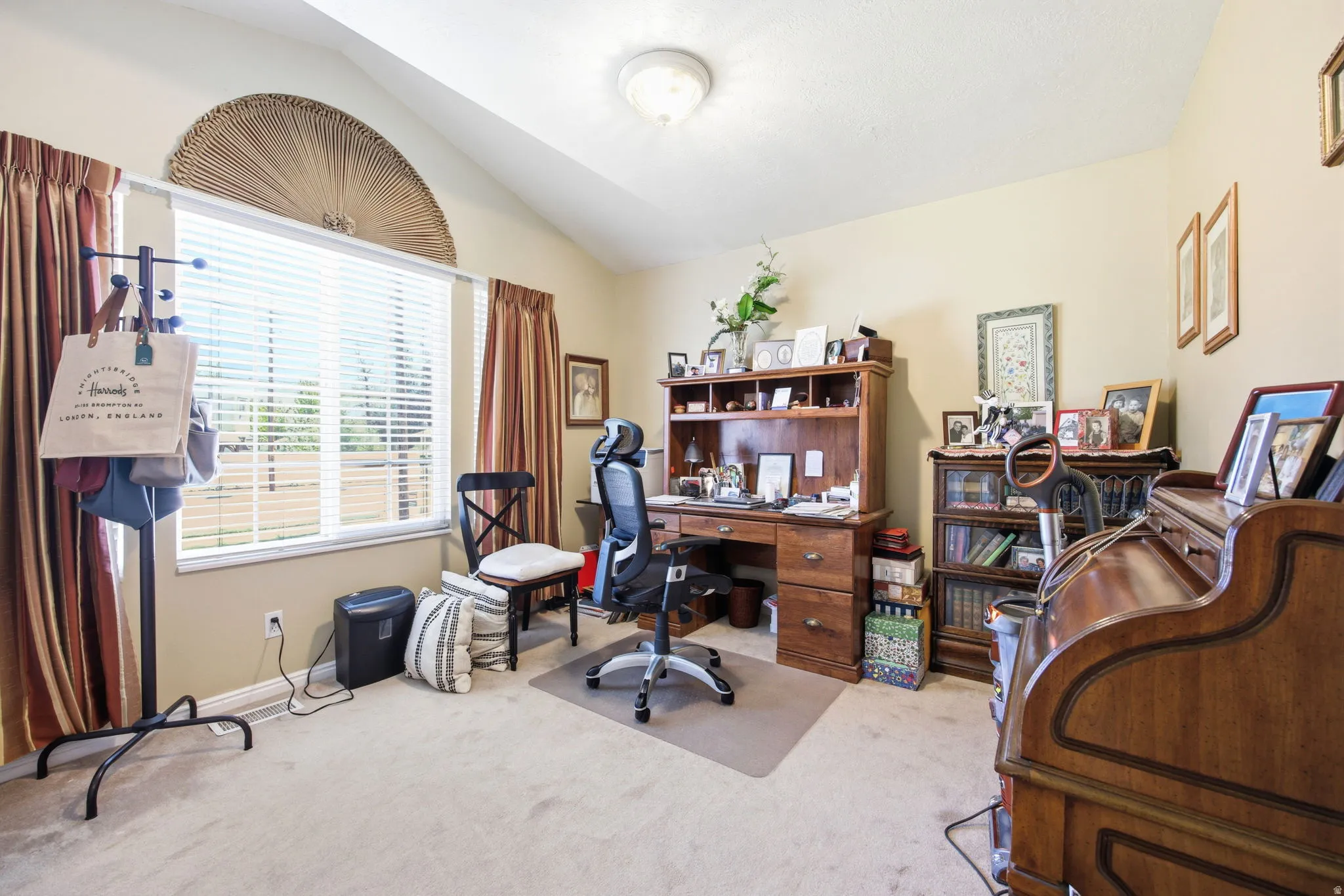 Vaulted ceiling room with neutral-toned walls