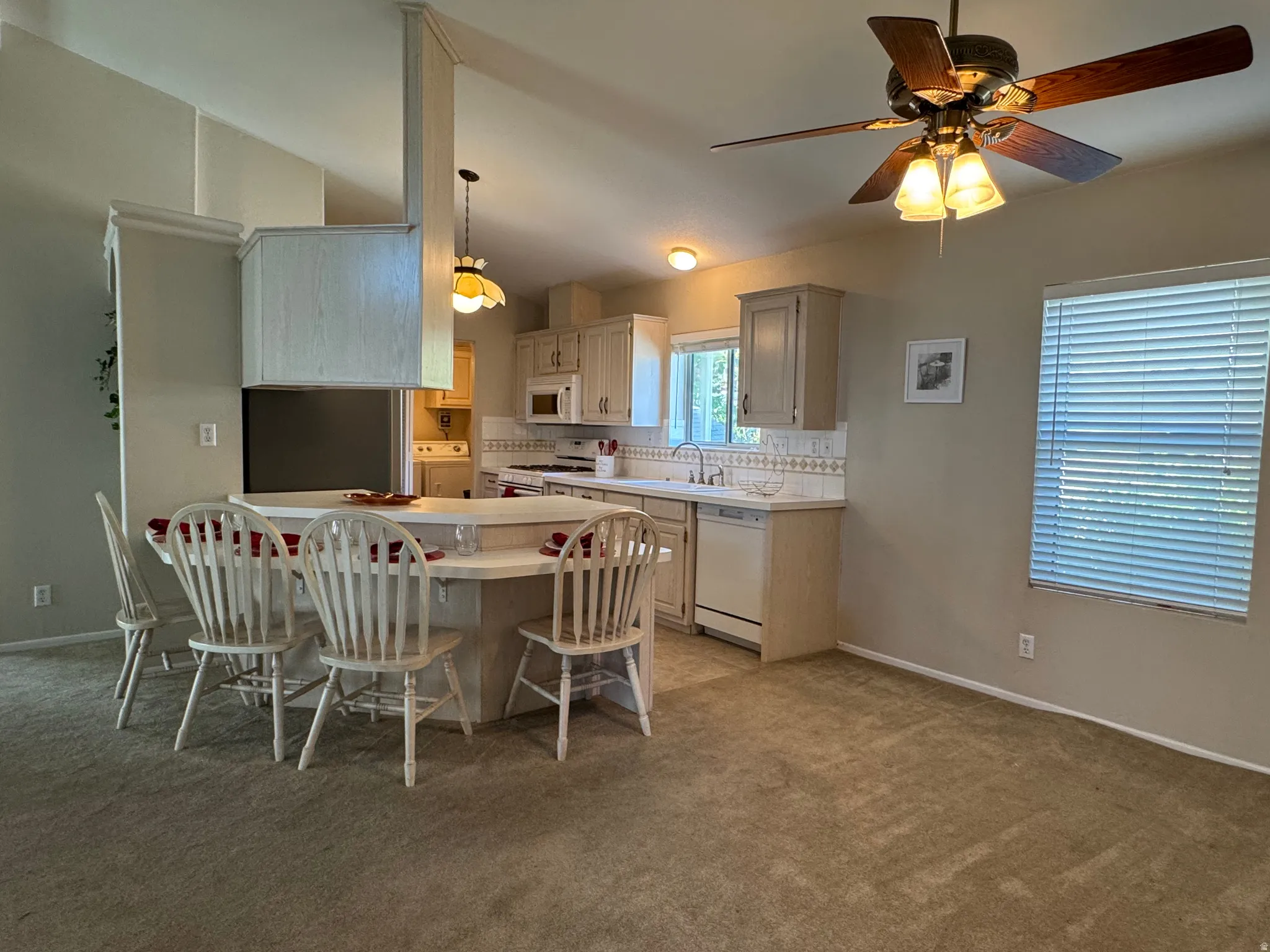 Kitchen featuring light cabinetry, a tile backsplash, and a built-in breakfast bar with seating