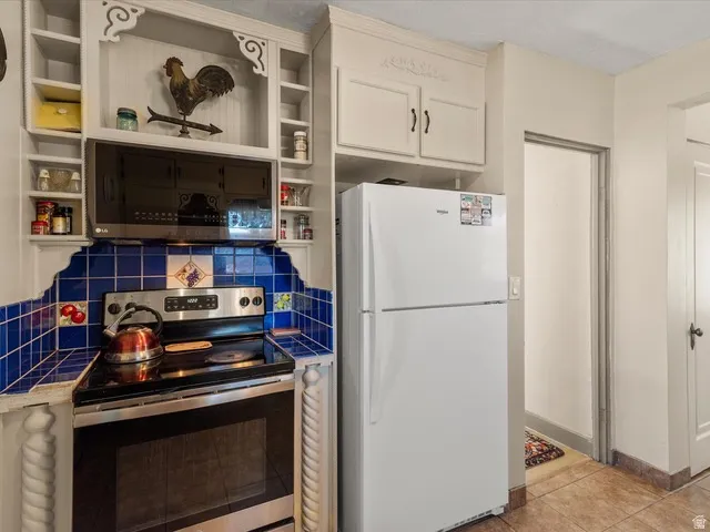 Kitchen featuring an electric range, over-the-range microwave, and built-in shelving