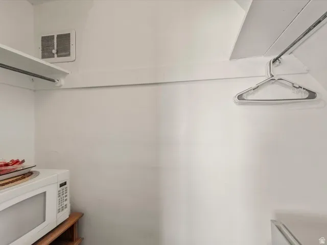 White interior walls with a built-in shelf and clothing rod