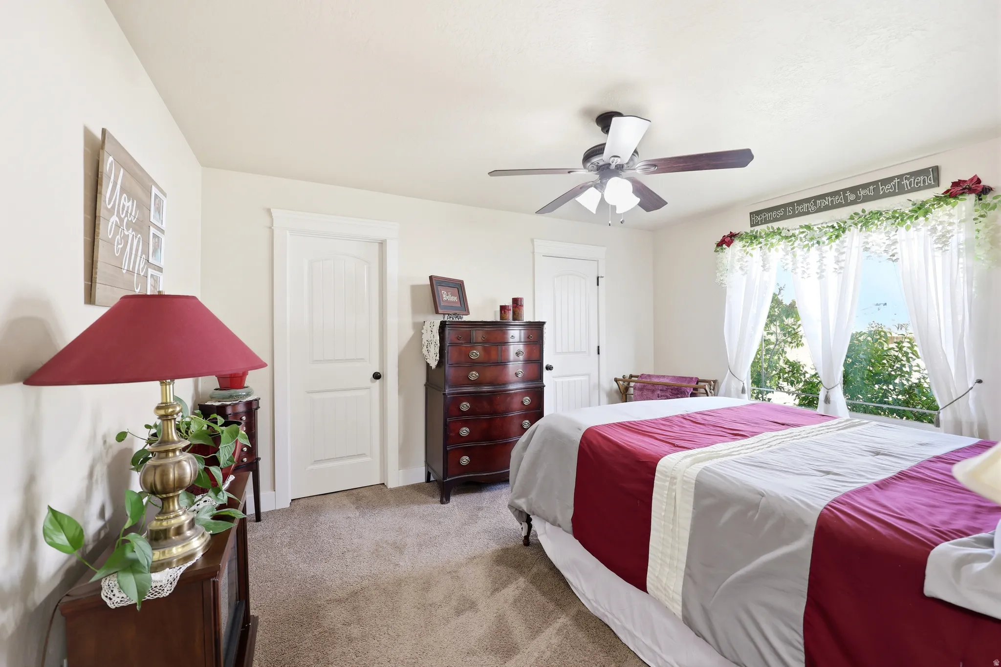 Carpeted bedroom with a ceiling fan