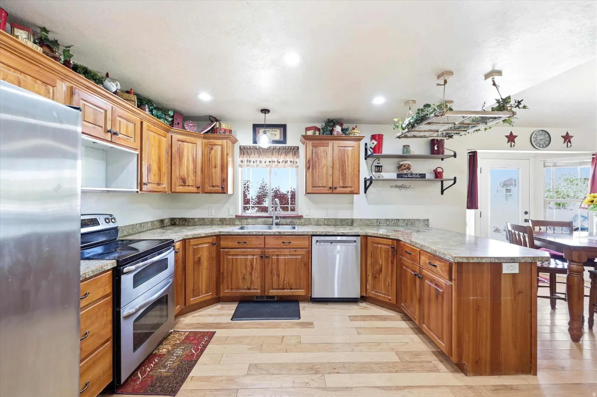 Kitchen featuring wood-finish cabinetry, light-toned countertops, and stainless steel appliances