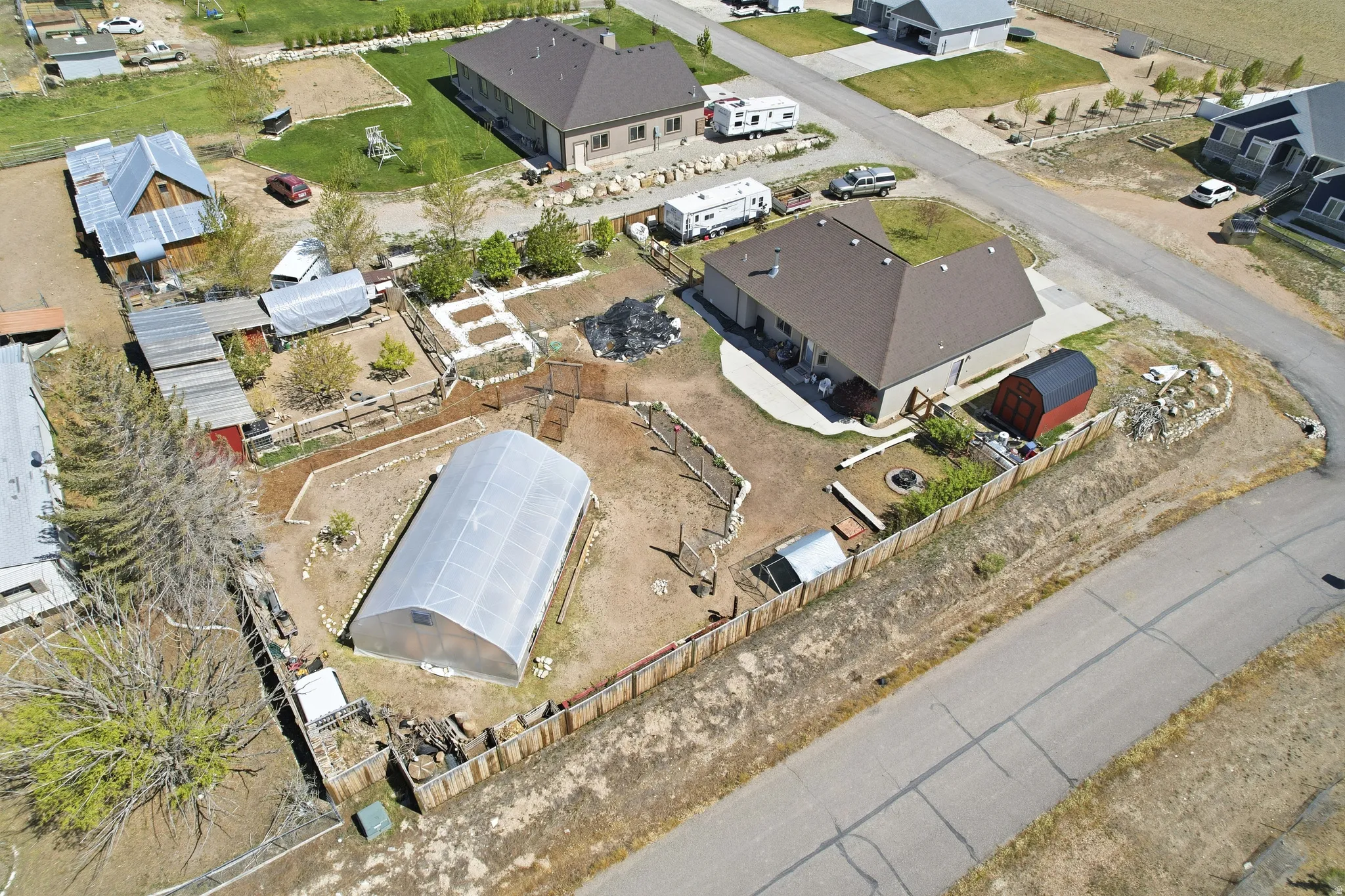 Expansive property featuring a large greenhouse, established garden beds, and multiple outbuildings.  Red shed is excluded, but negotiable.