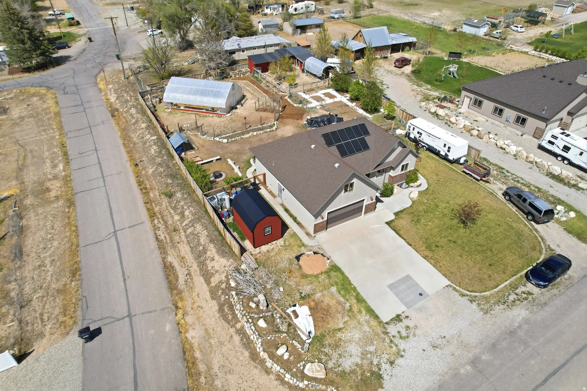 Contemporary residence featuring a two-car garage, solar panel installation, and a substantial driveway.  Red shed is excluded, but negotiable.