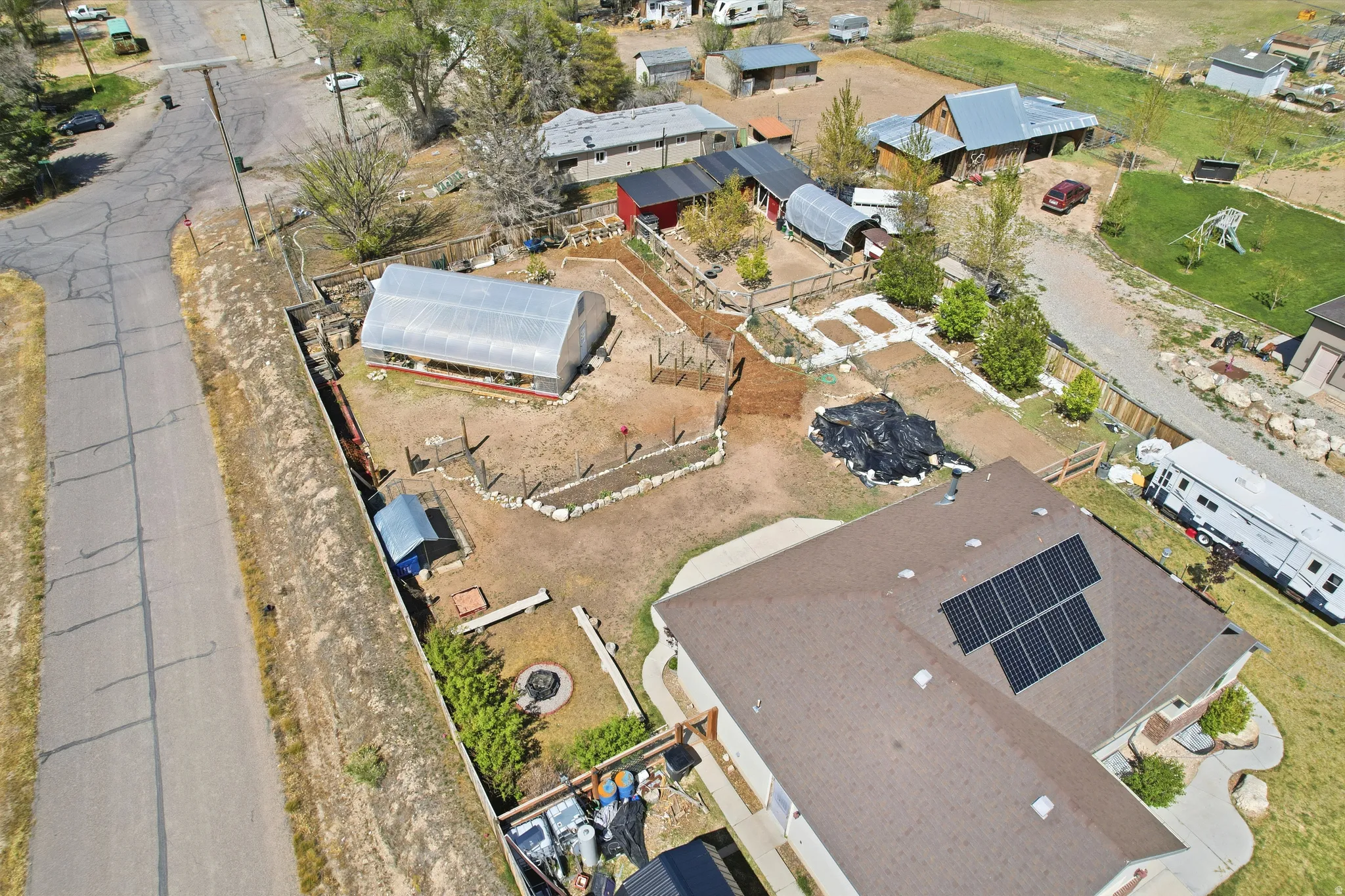Expansive property featuring a large hightunnel greenhouse and raised garden beds