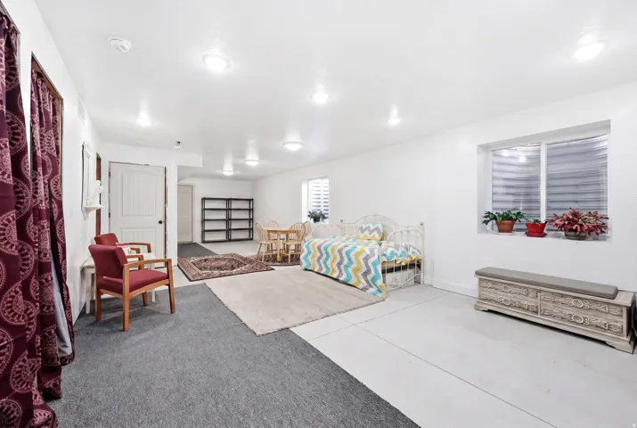 Spacious area featuring recessed lighting, a window with horizontal blinds, and a combination of carpet and hard surface flooring