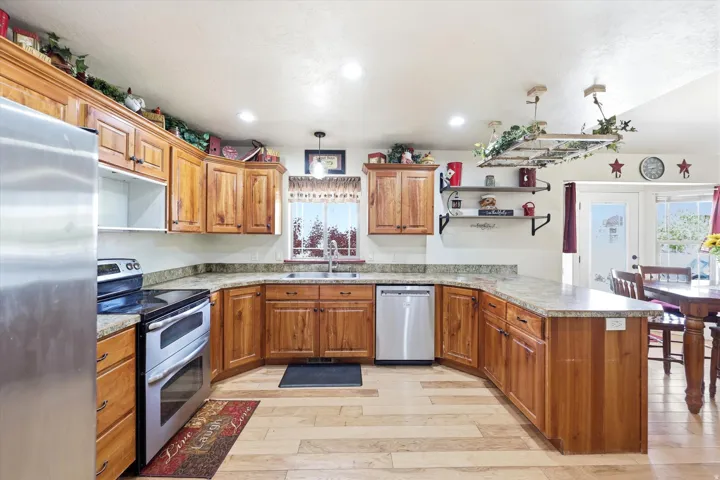 Kitchen featuring wood-finish cabinetry, light-toned countertops, and stainless steel appliances