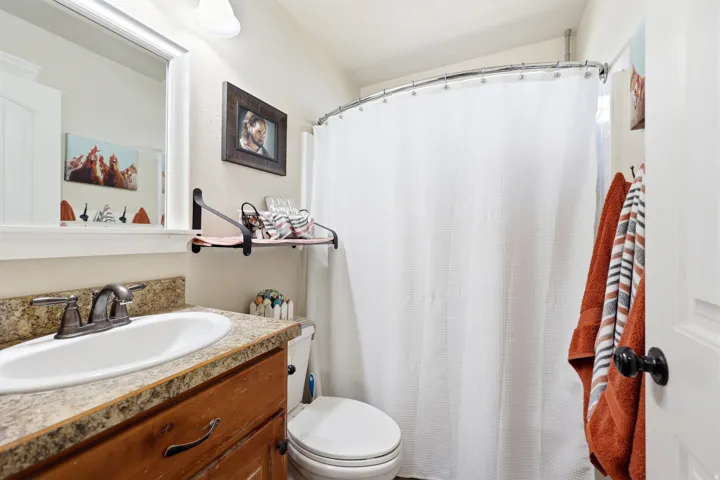 Bathroom vanity featuring a rectangular sink, speckled countertop, and dark wood-finish cabinetry