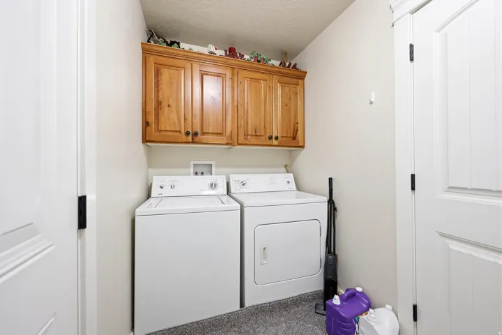 Laundry area featuring light wood cabinetry, white interior doors, and a neutral wall color