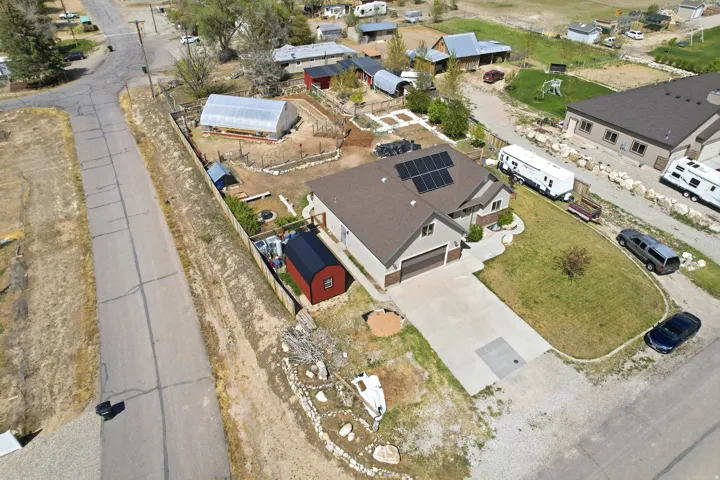 Contemporary residence featuring a two-car garage, solar panel installation, and a substantial driveway.  Red shed is excluded, but negotiable.