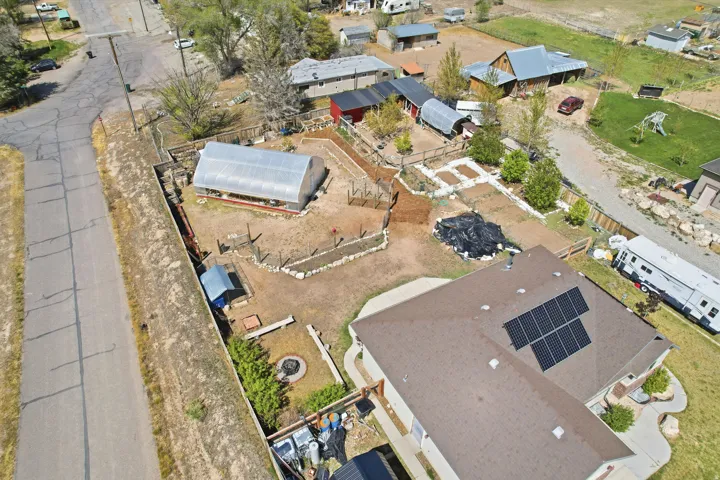 Expansive property featuring a large hightunnel greenhouse and raised garden beds