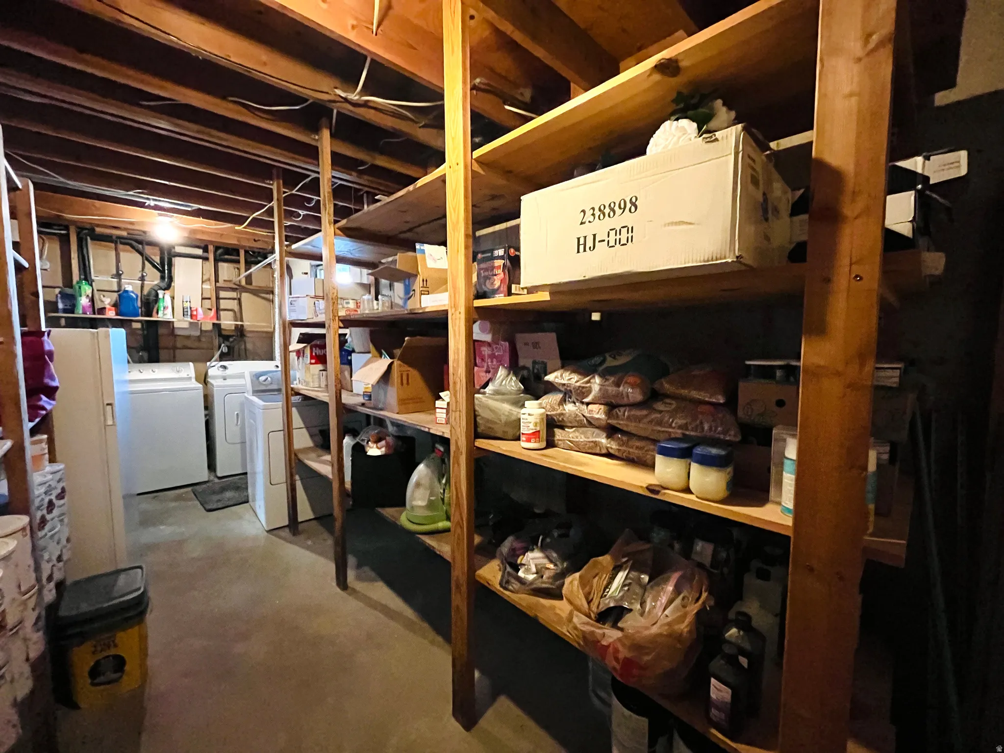 A combined laundry and storage room offers added convenience, complete with built-in shelving to keep everything organized and within reach.