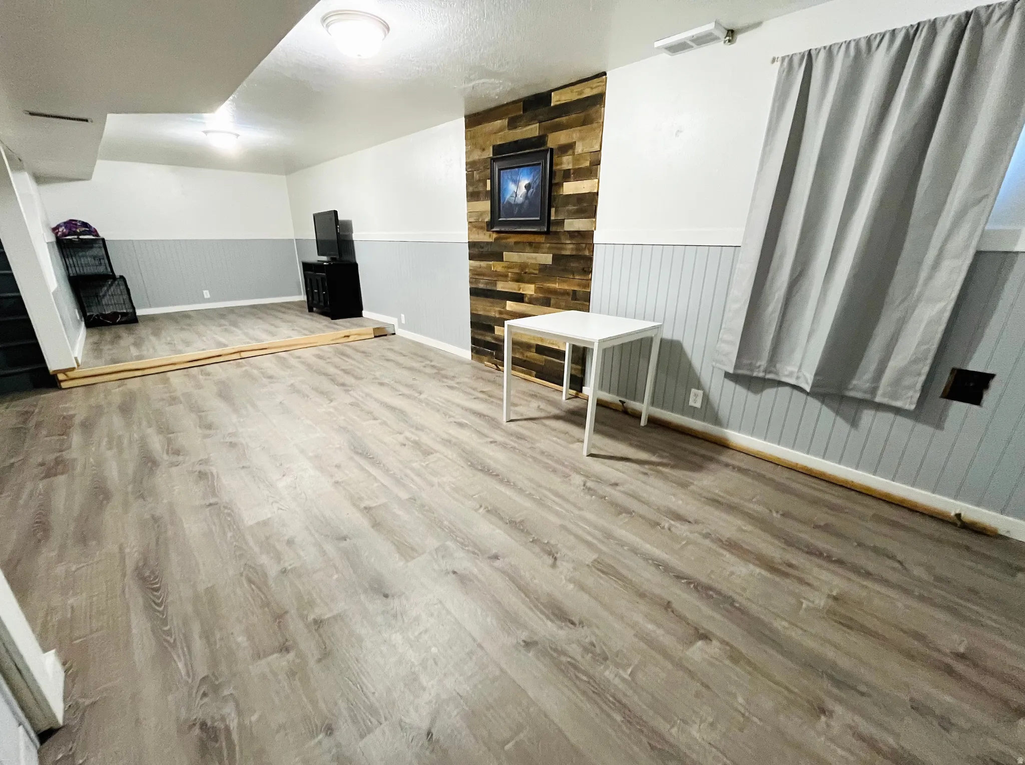 Spacious basement family room featuring durable LVP flooring, offering the perfect space for movie nights, game days, or relaxing with family and friends.