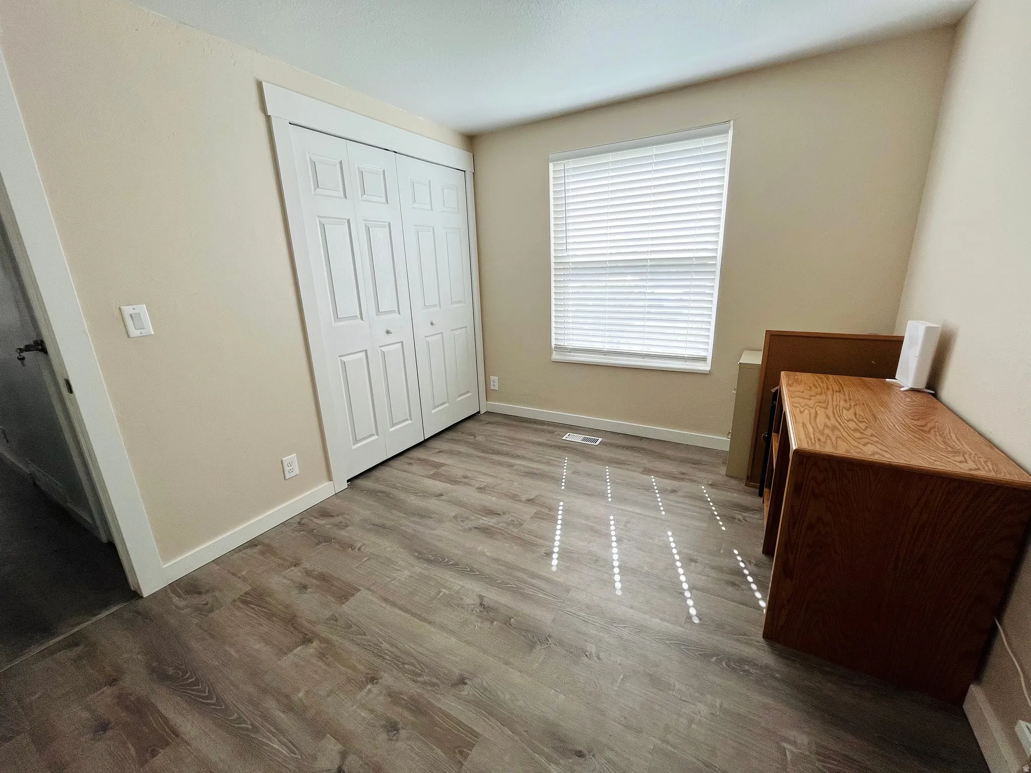 Bedroom or home office with light wood-type flooring and baseboards