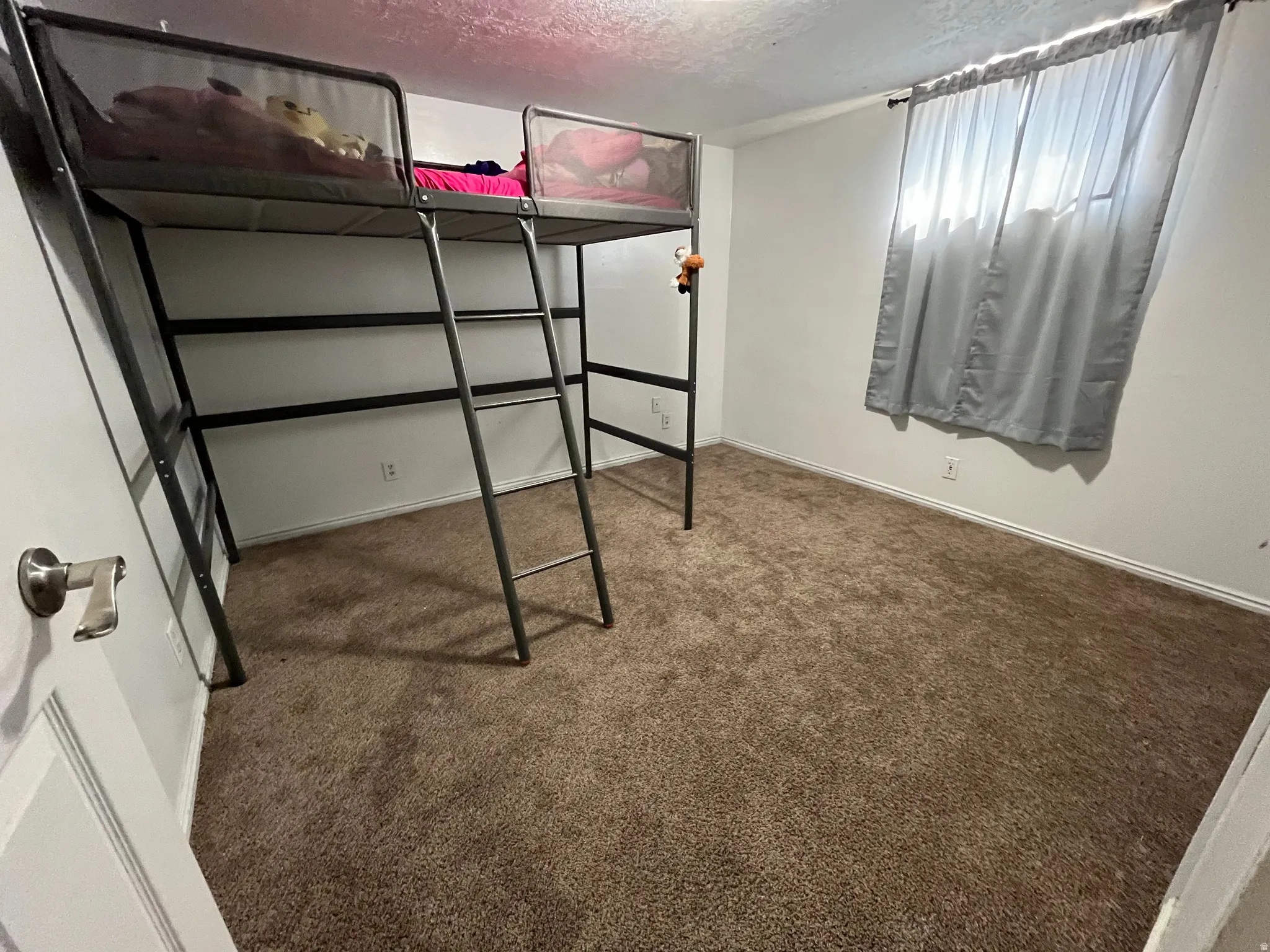 A well-sized bedroom with plush carpet and inviting atmosphere, perfect for rest and relaxation.