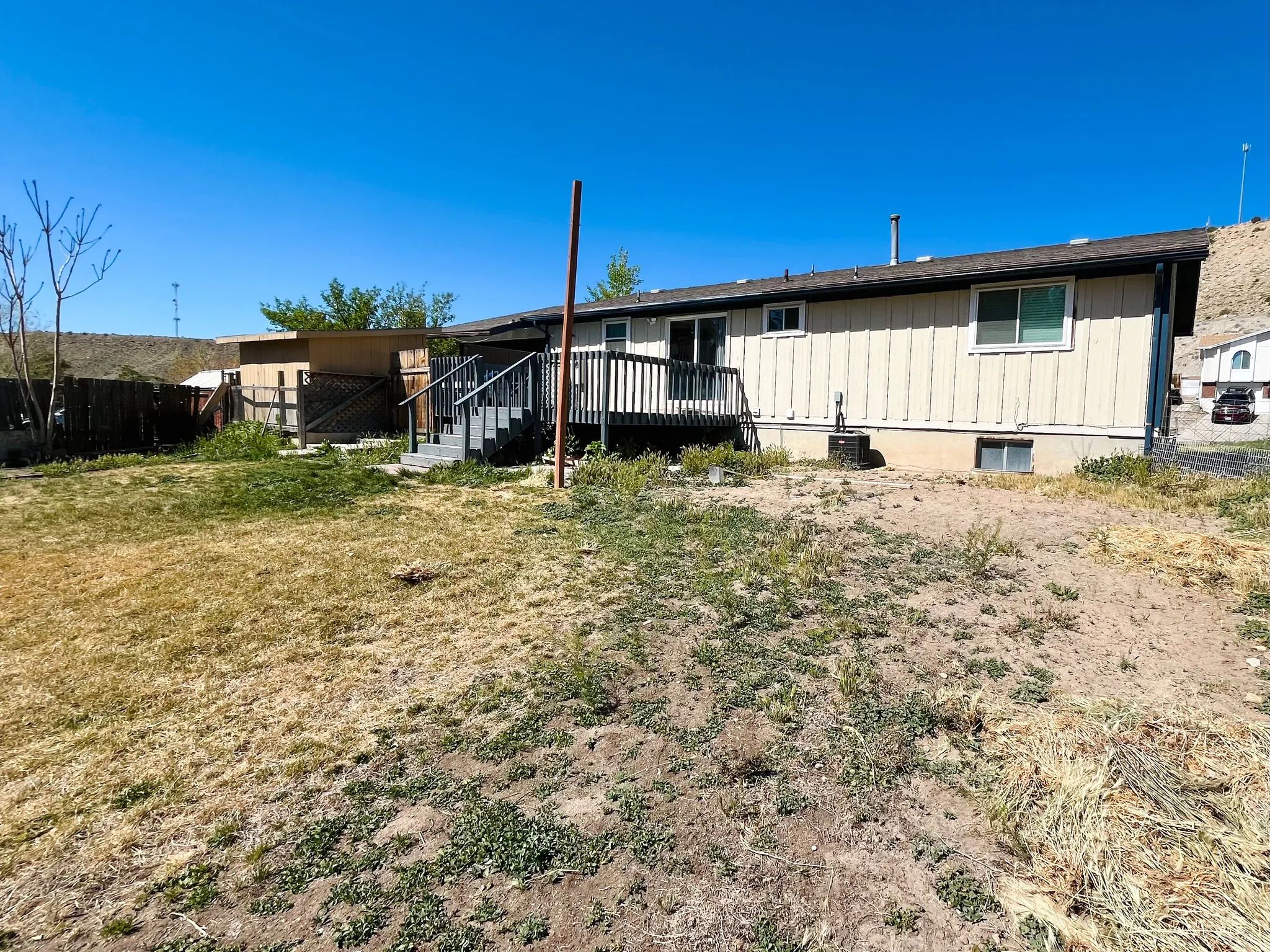 A large, fully fenced backyard offers privacy and room to roam, featuring raised garden beds ready for planting and outdoor enjoyment.