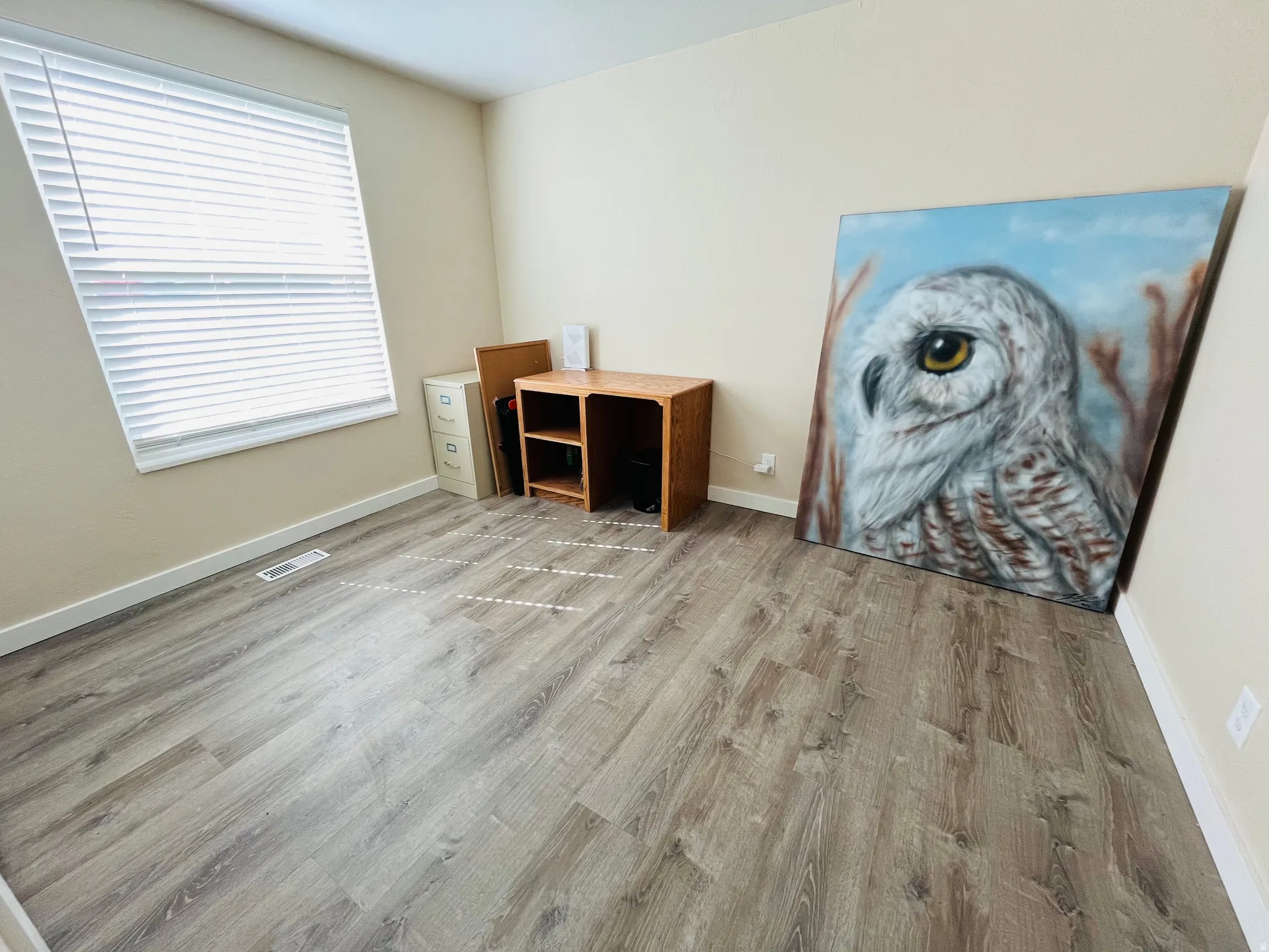 Bedroom or home office with light wood-type flooring and baseboards