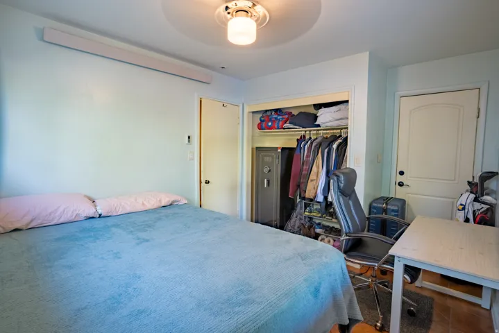Interior room featuring a built-in closet with shelving and hanging rods, a ceiling-mounted light fixture, and two interior doors