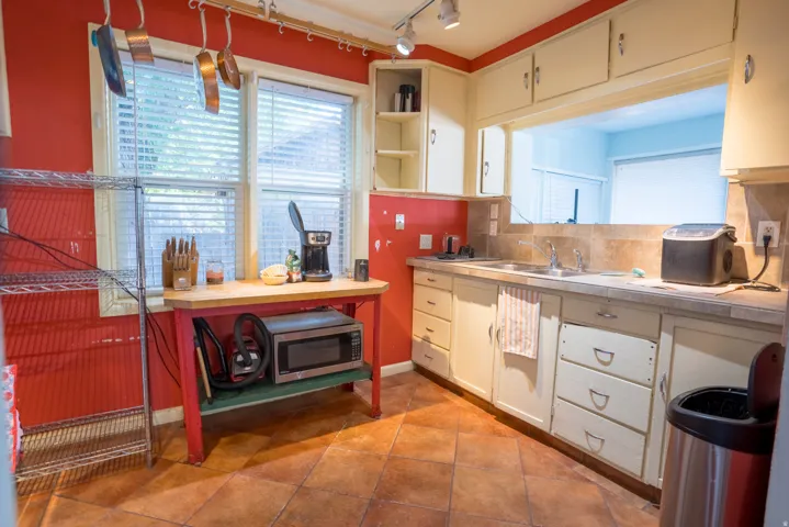 Kitchen featuring cream-colored cabinetry, tile flooring, and a pass-through window