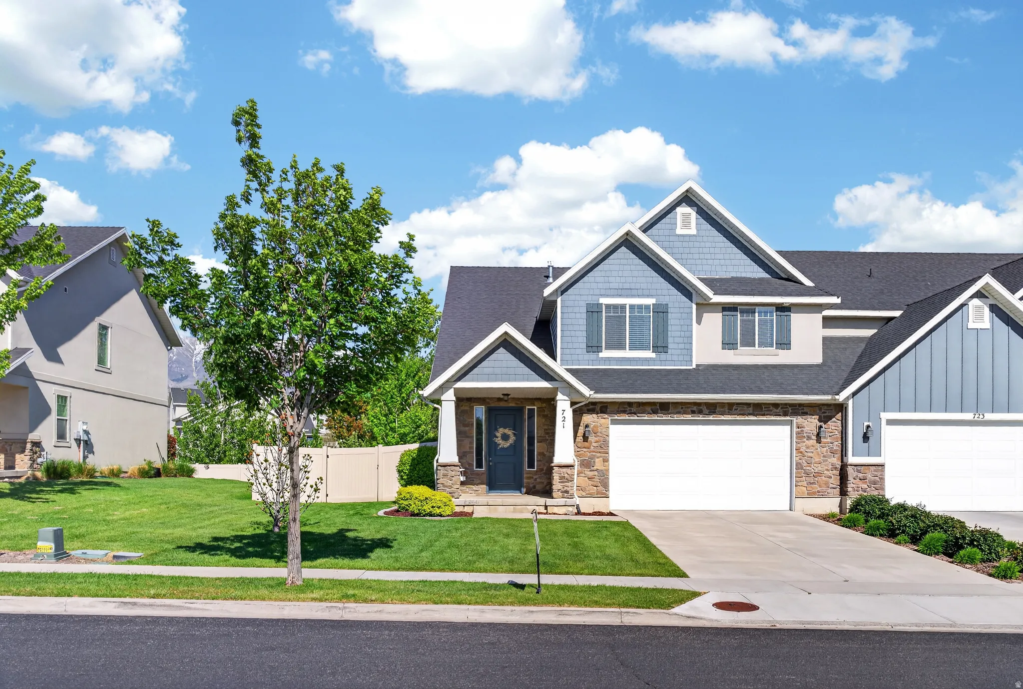 Two-story residence featuring a stone facade, blue siding, and white trim accents