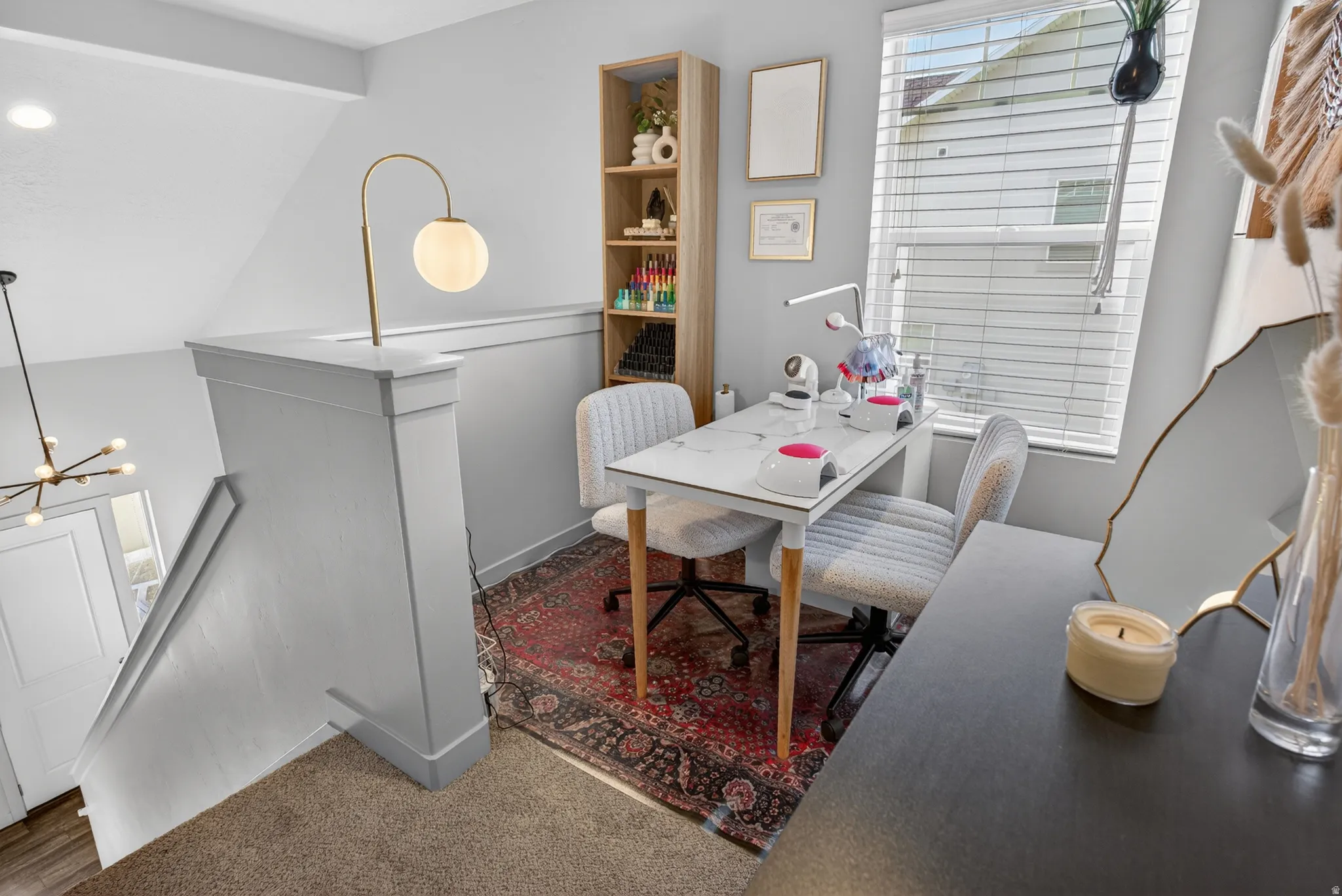 Carpeted landing featuring a built-in shelf, large window with blinds, and a modern light fixture