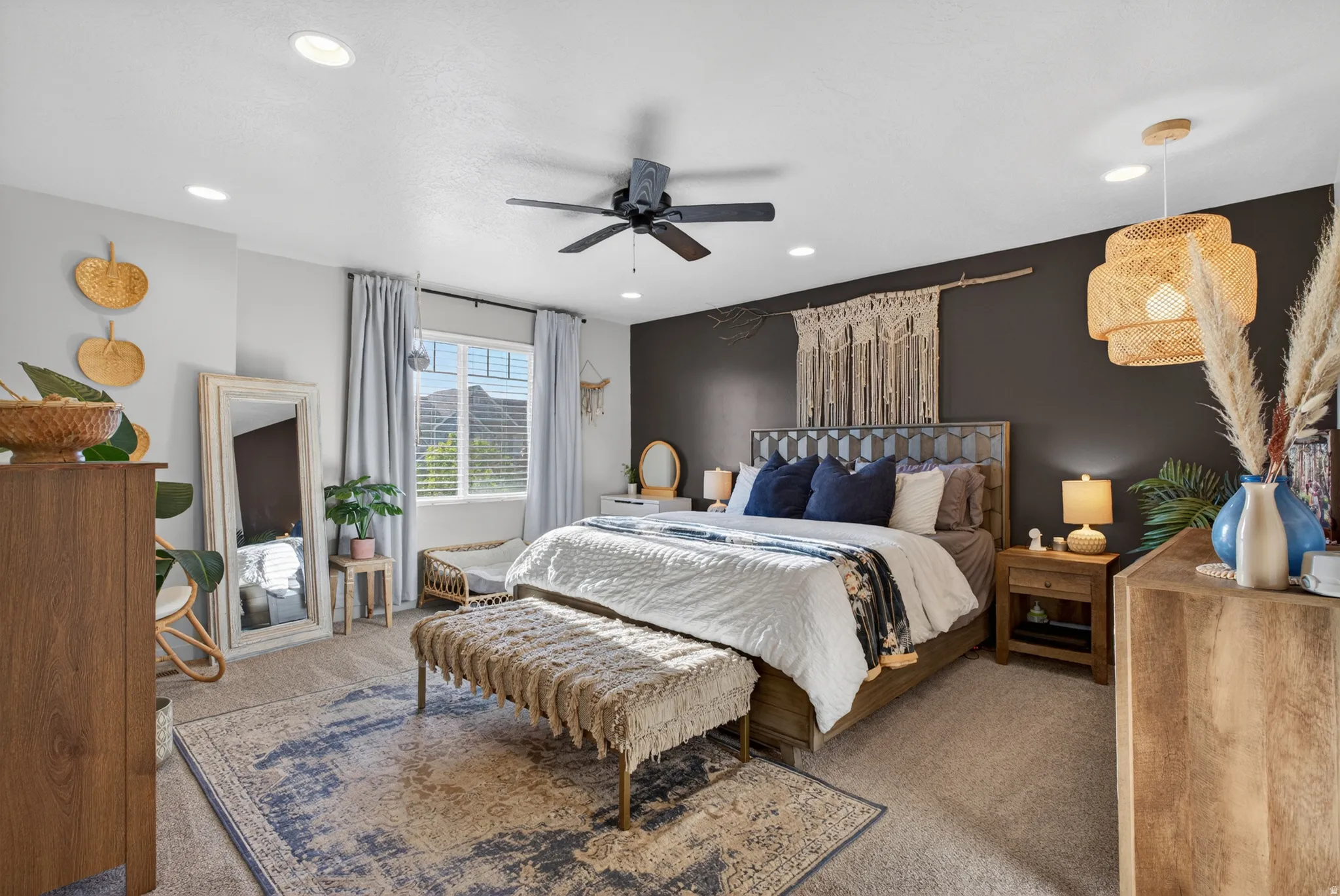 Spacious bedroom with an accent wall, window with blinds, recessed lighting, ceiling fan, and carpeted flooring