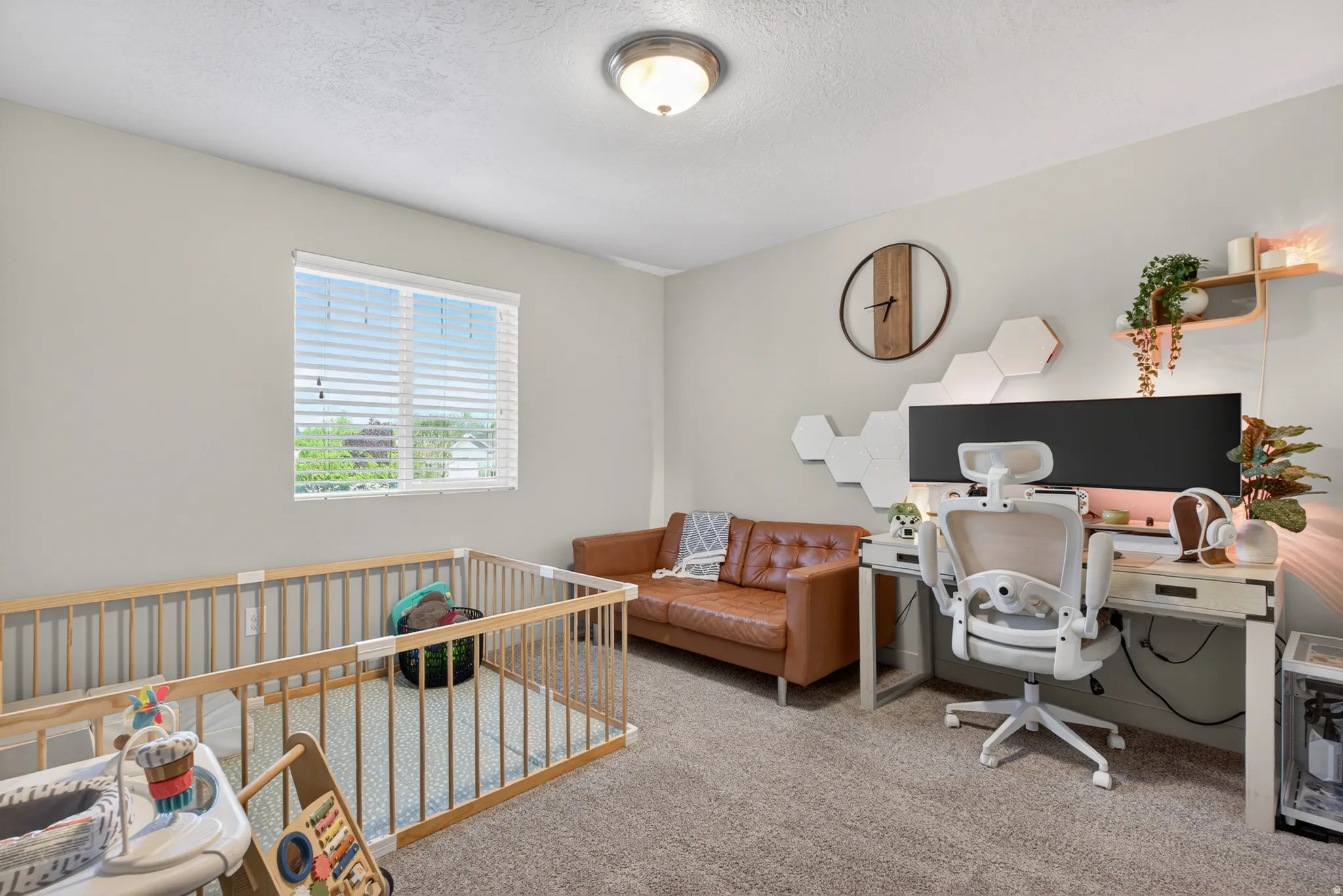Carpeted room featuring a window with horizontal blinds, light gray walls, and a ceiling-mounted light fixture