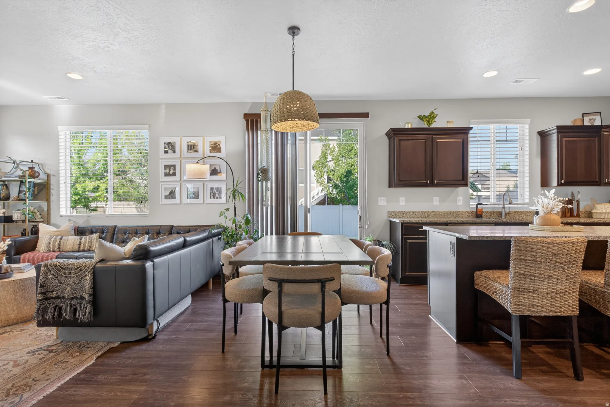 Open-concept living area featuring wood-finish flooring, recessed lighting, and multiple windows