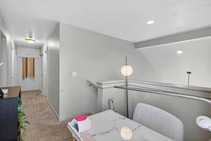 Loft area with a half-wall railing, recessed ceiling lighting, and neutral wall paint
