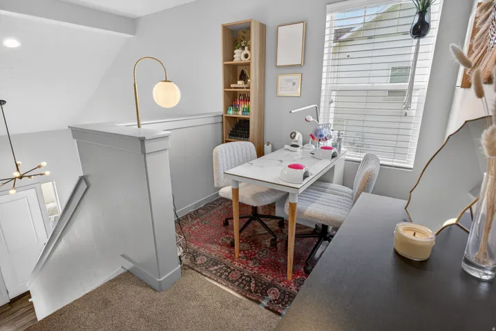 Carpeted landing featuring a built-in shelf, large window with blinds, and a modern light fixture