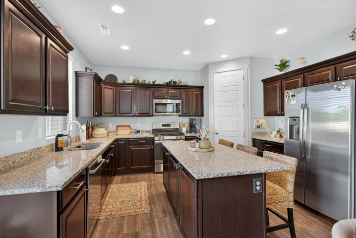 Kitchen featuring dark wood cabinetry, light-toned countertops, and wood-finish flooring