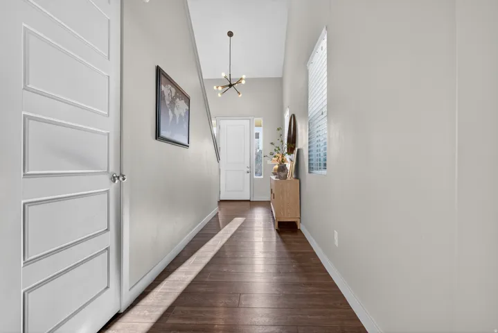 Entryway featuring wood-finish flooring, light grey walls, and a modern sputnik chandelier