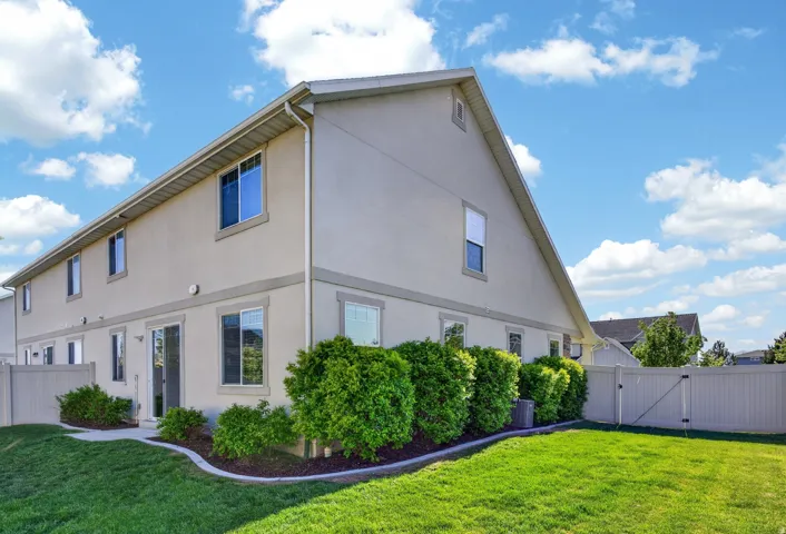 Stucco exterior featuring multiple windows and a sliding glass door