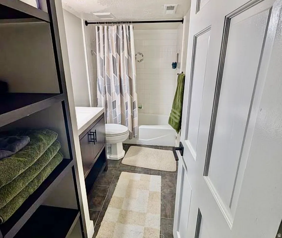 Bathroom featuring a white paneled door, dark wood-finish vanity with white countertop, and tiled flooring