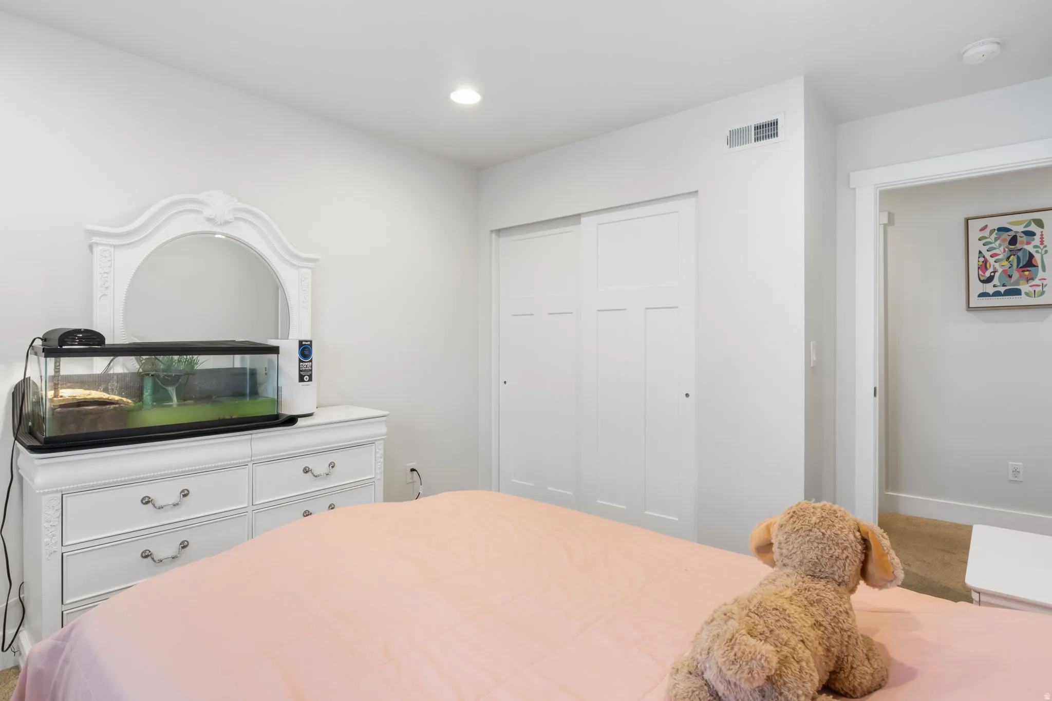 Bedroom featuring white walls, recessed lighting, and a built-in sliding closet with paneled doors