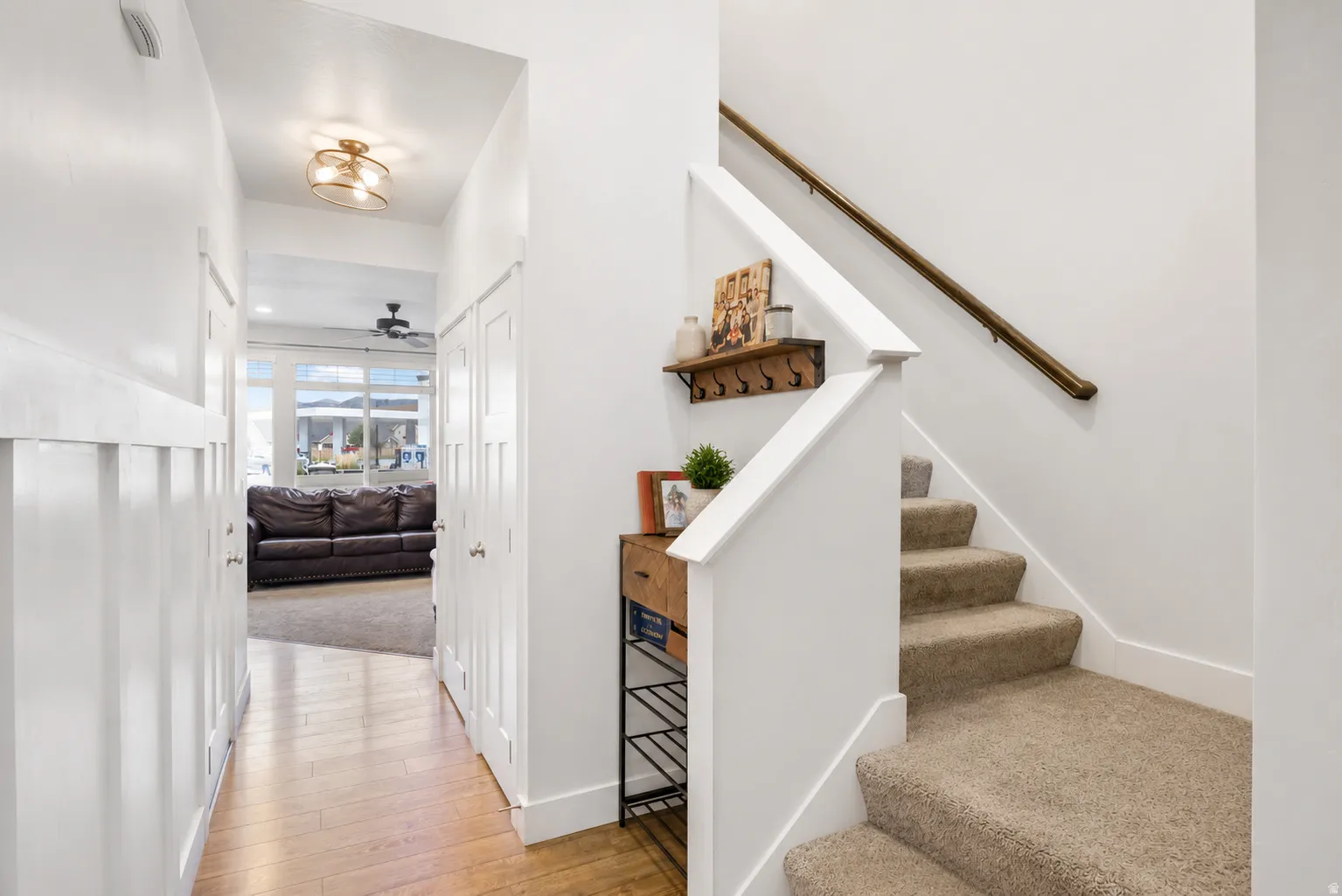 Entryway featuring wood-finish flooring, white board and batten wall paneling, and a contemporary flush-mount ceiling light