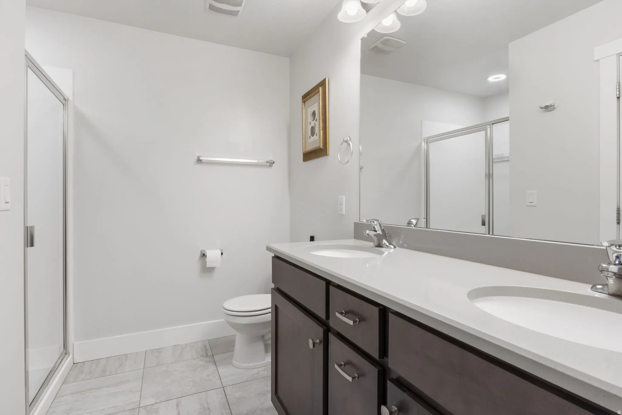 Bathroom featuring a dual vanity with undermount sinks and contemporary faucets