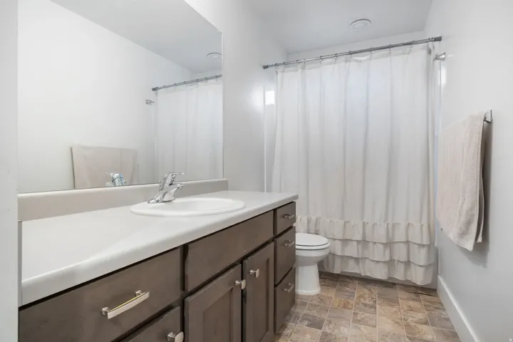 Bathroom featuring a vanity with a light-colored countertop, an integrated sink, and dark wood-finish cabinetry