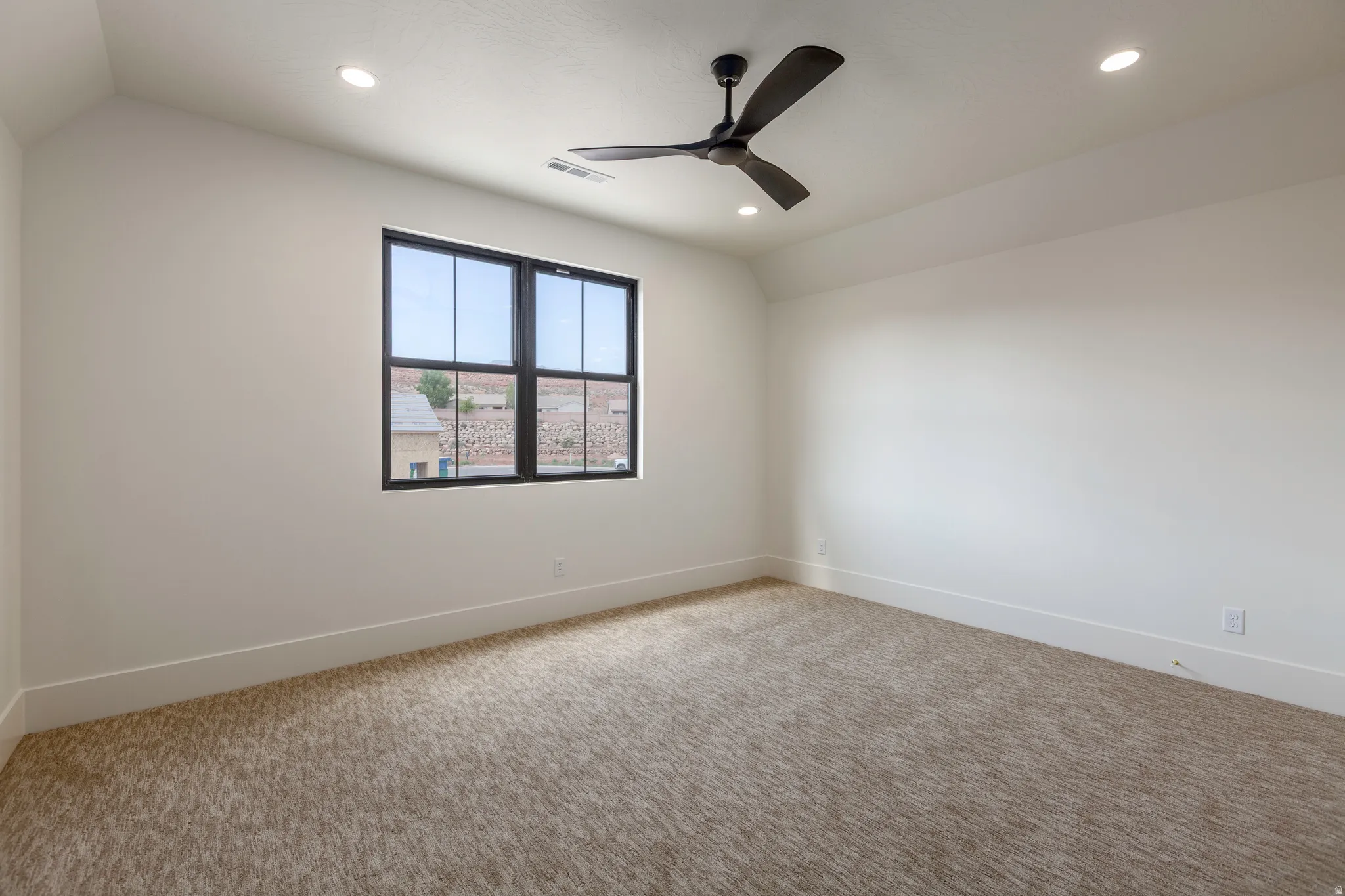 Spacious room featuring neutral carpeting, recessed lighting, and a contemporary ceiling fan