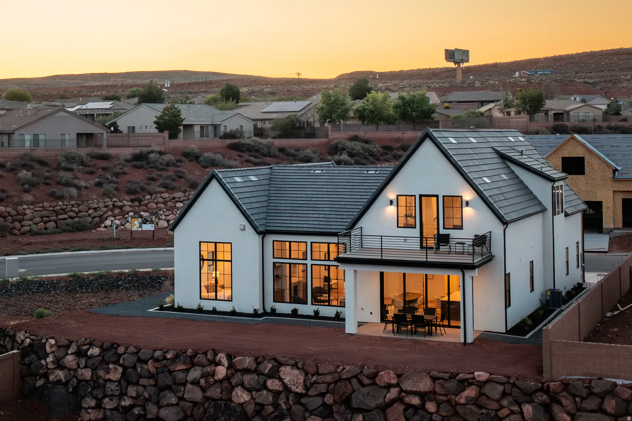 Modern white stucco exterior with a dark-tiled roof and black-framed windows