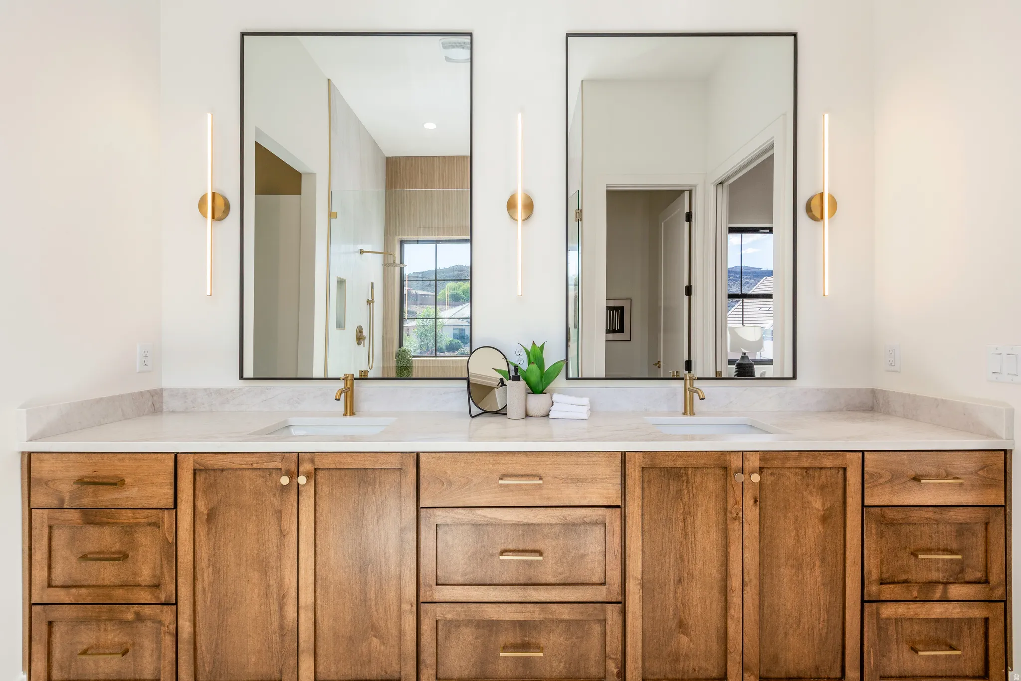 Double vanity featuring a light-toned countertop, dual rectangular undermount sinks, and bronze-finish faucets