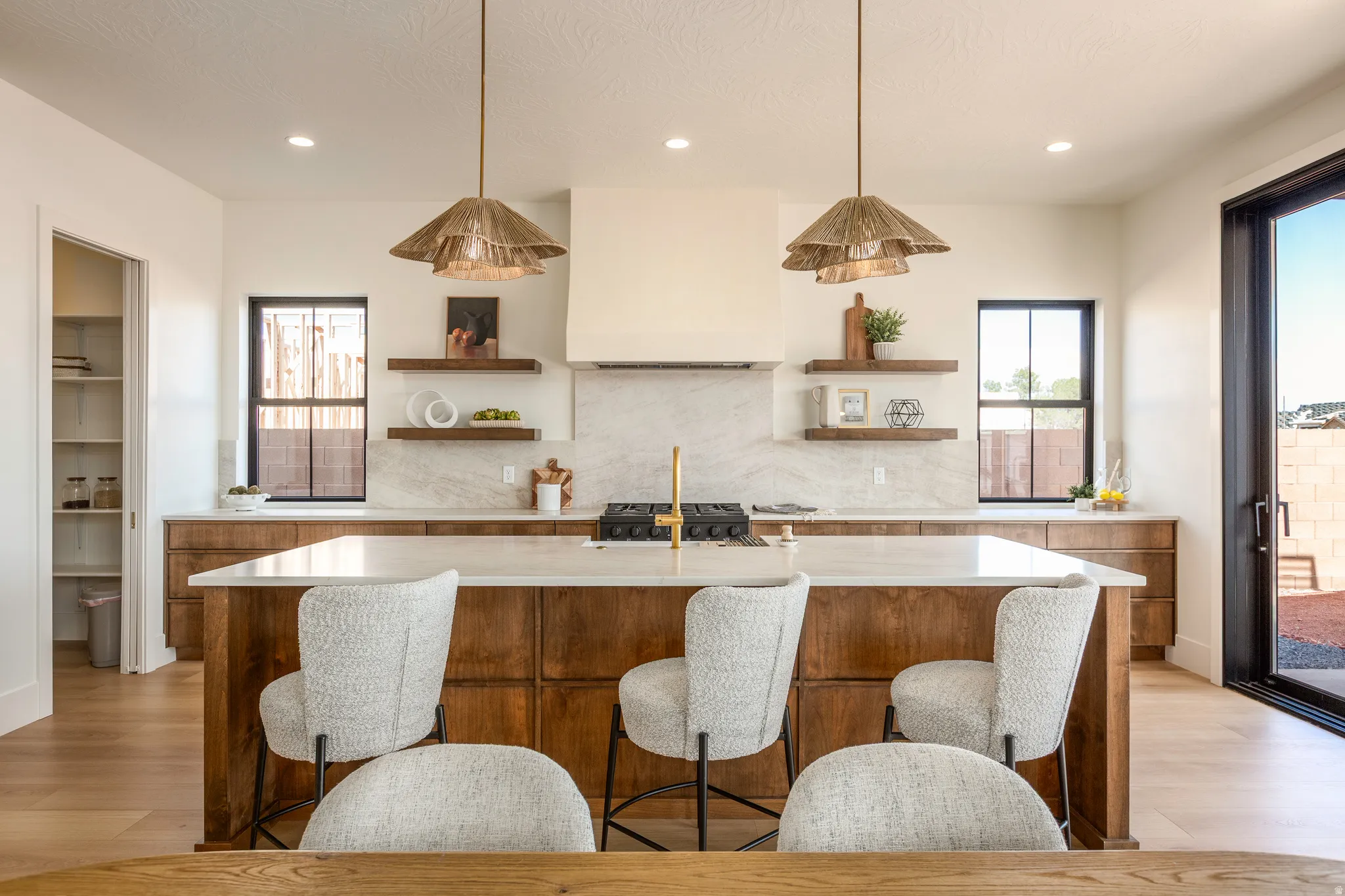 Kitchen featuring a wood-finish island with seating, a gas range, and a full-height stone backsplash